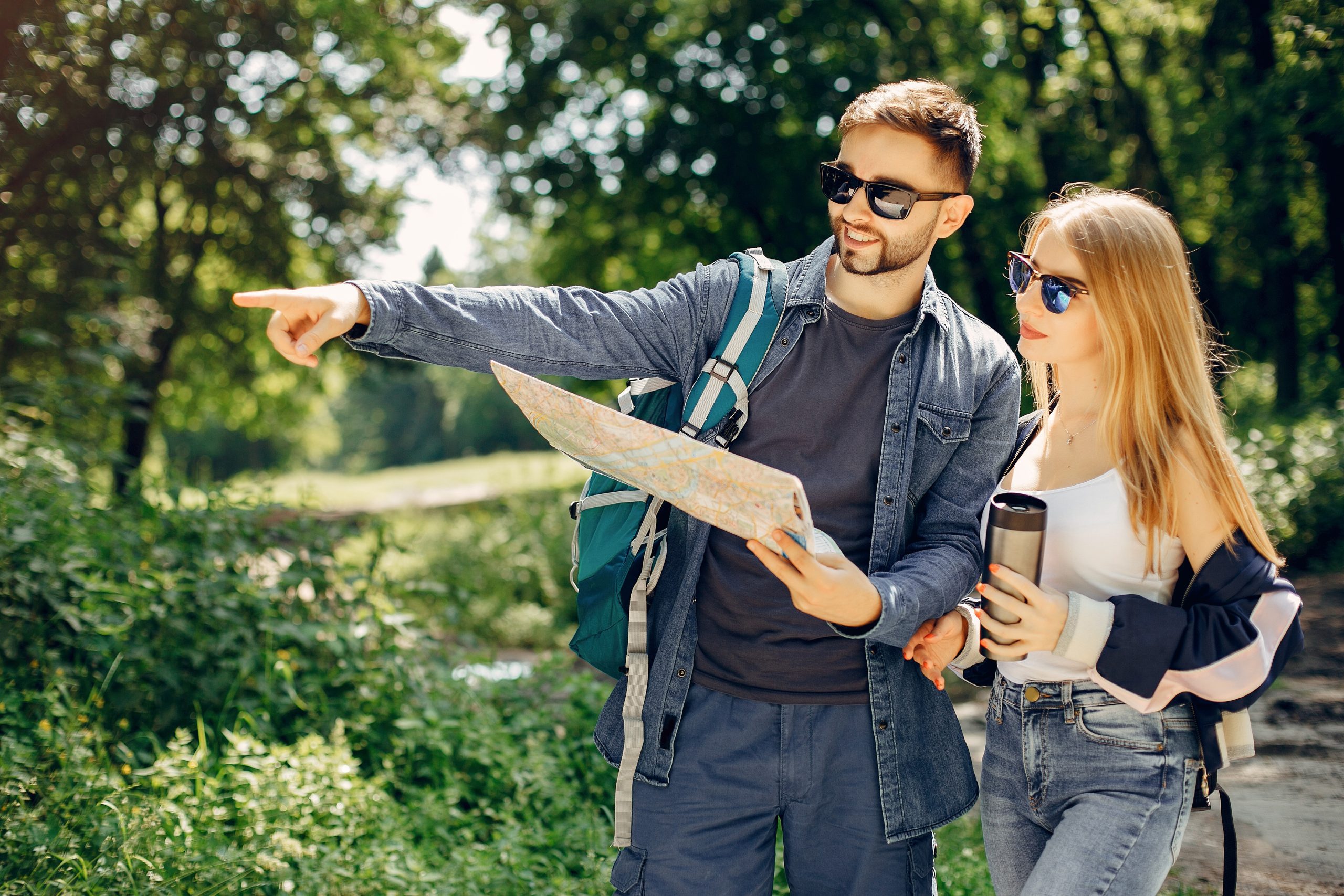 Young couple reading map and hiking